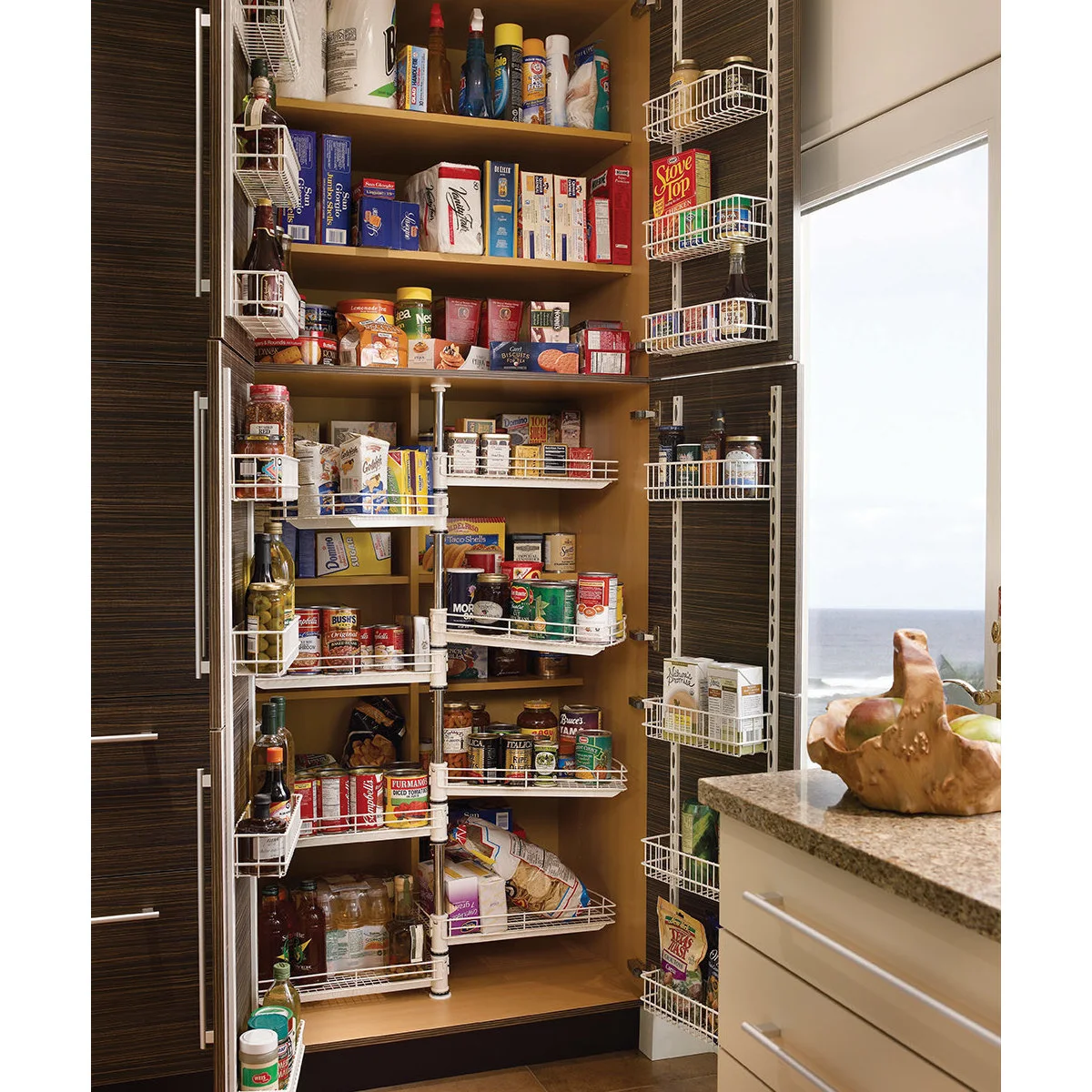 Tall pantry with wire door racks and rotating inner baskets holding packaged food