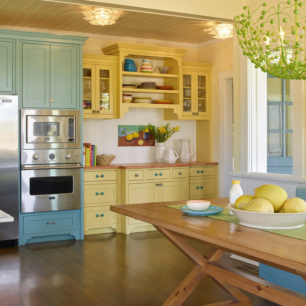 Pale yellow plate display and wood-colored counter beside a blue appliance cabinet