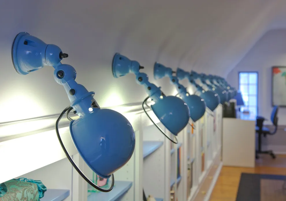 A row of blue adjustable lamps sits above an attic work surface