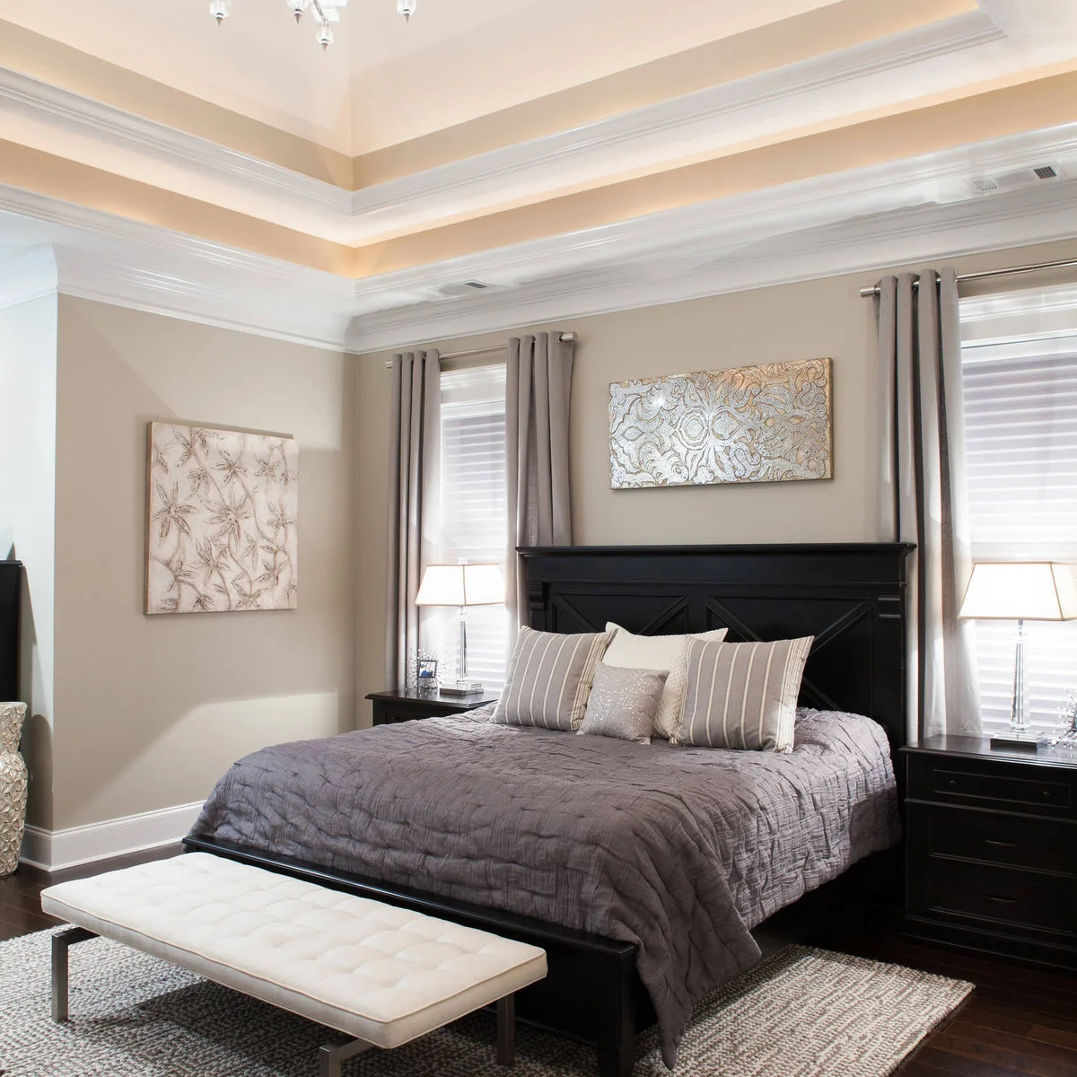 Small horizontal patterned artwork above a dark wooden headboard between gray curtains and white blinds.