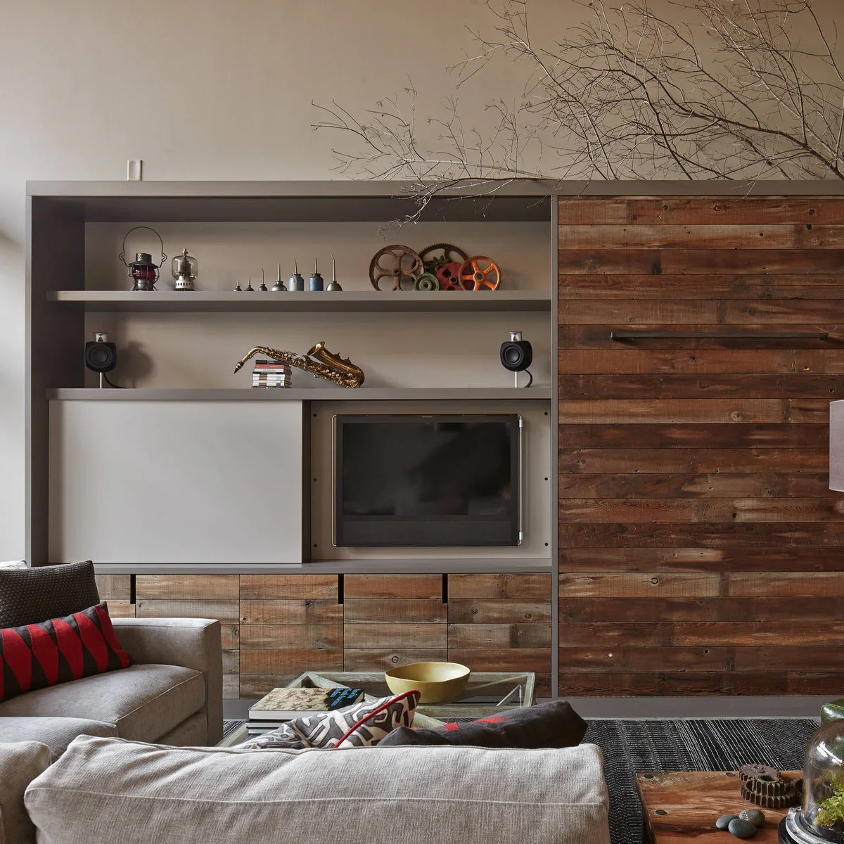 Media wall with rustic wood fronts, a sliding pale panel and open display shelves