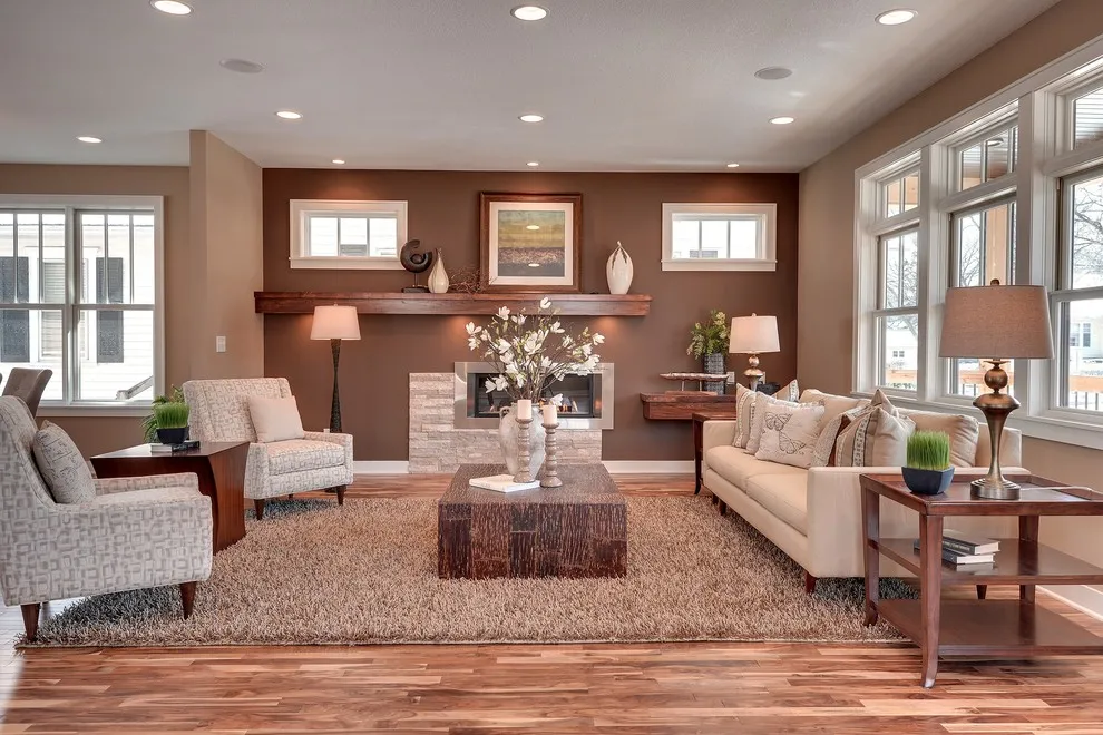A red-brown wall sits behind pale seating and framed pictures