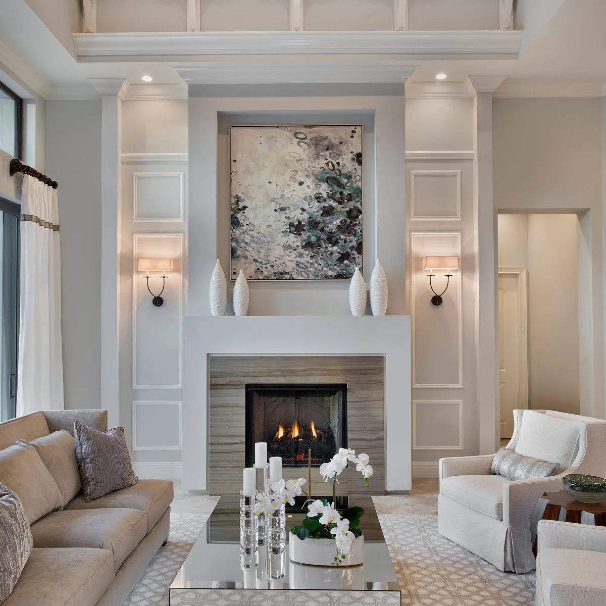 Two dark double-arm wall lights with pale shades sit on white paneled piers beside fireplace artwork.
