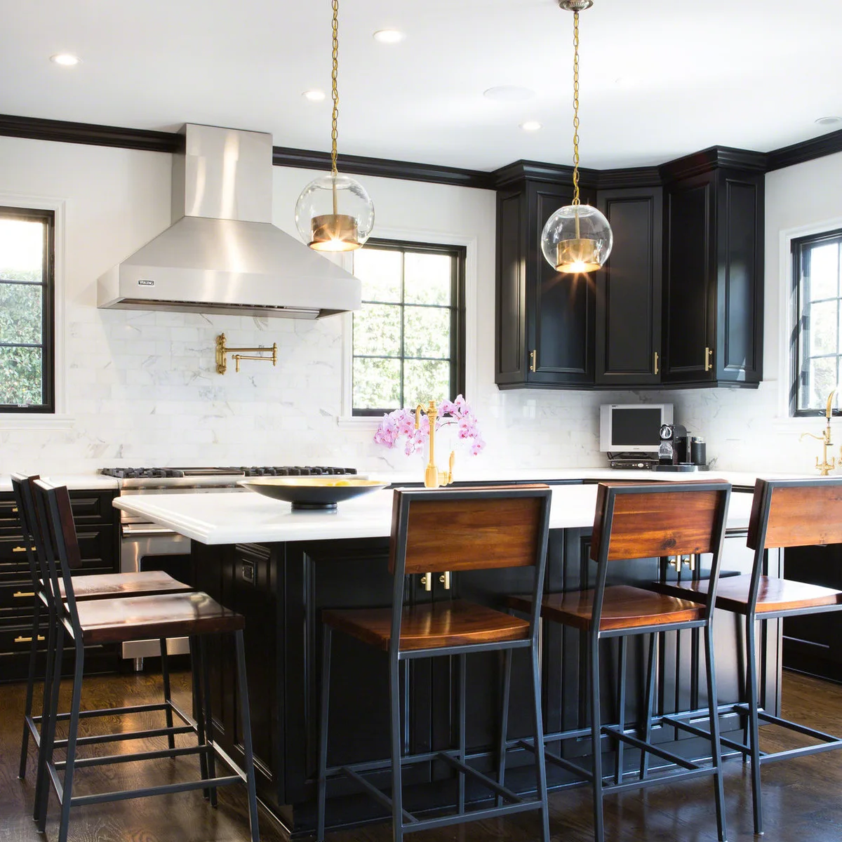 Kitchen stools with wood seats and rectangular wood back panels within dark metal frames
