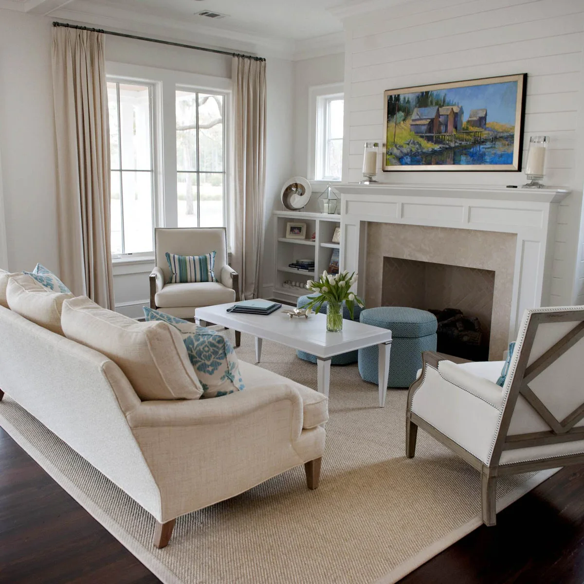 White-walled sitting room with a white fireplace and coffee table beside pale seating