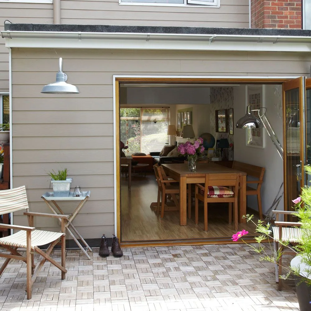 Small square timber-look floor sections form a repeating pattern outside wide folding doors