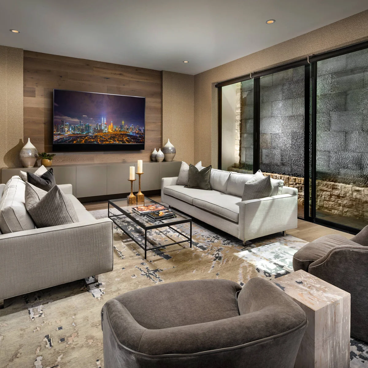 Living room with two white sofas, a slim black-framed glass table and television on the end wall