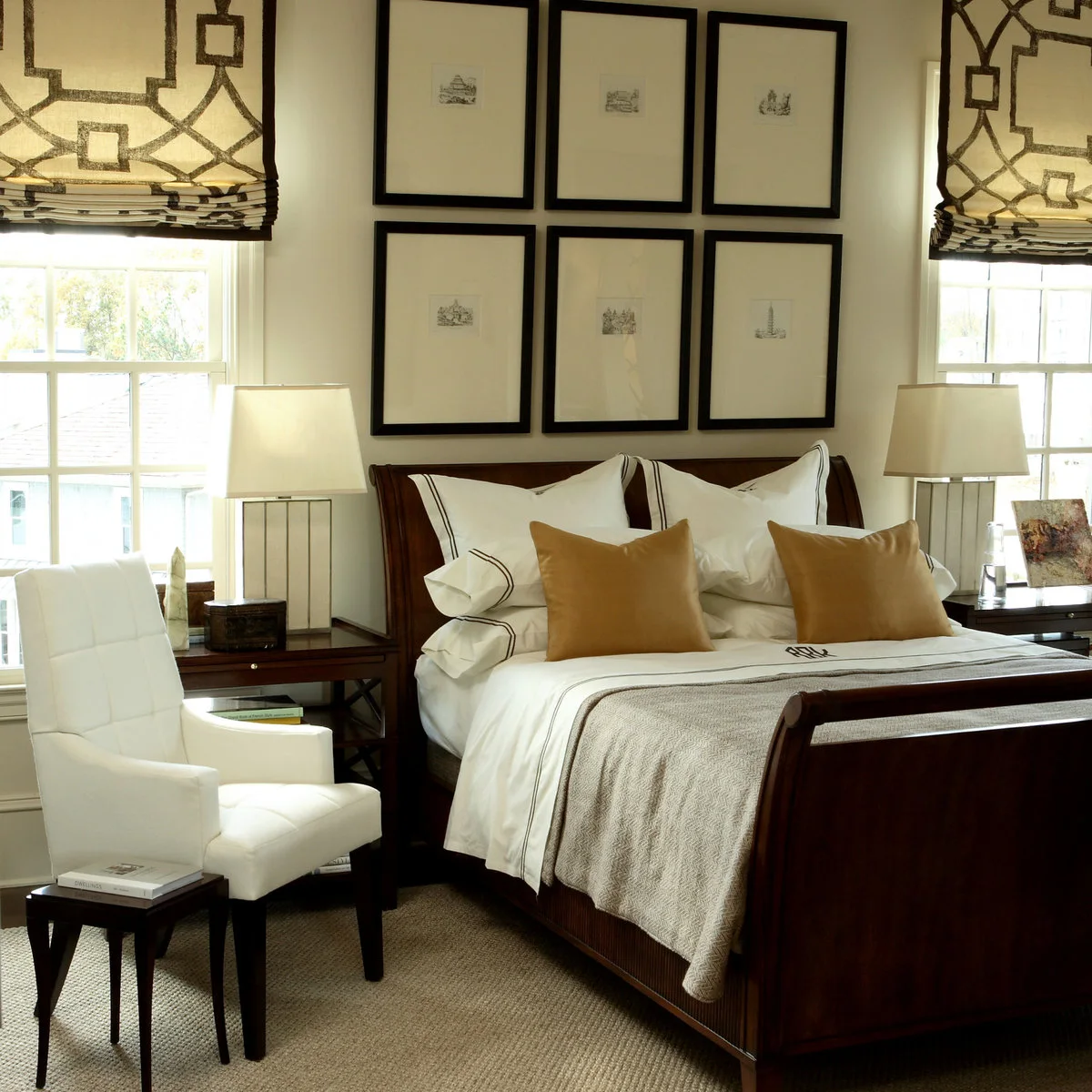 Six black-framed small drawings in two rows above a wooden bed between patterned window blinds.
