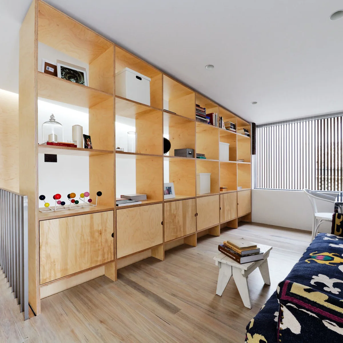 Balmain terrace with a pale wood-colored shelving wall, closed lower cabinets and sofa opposite