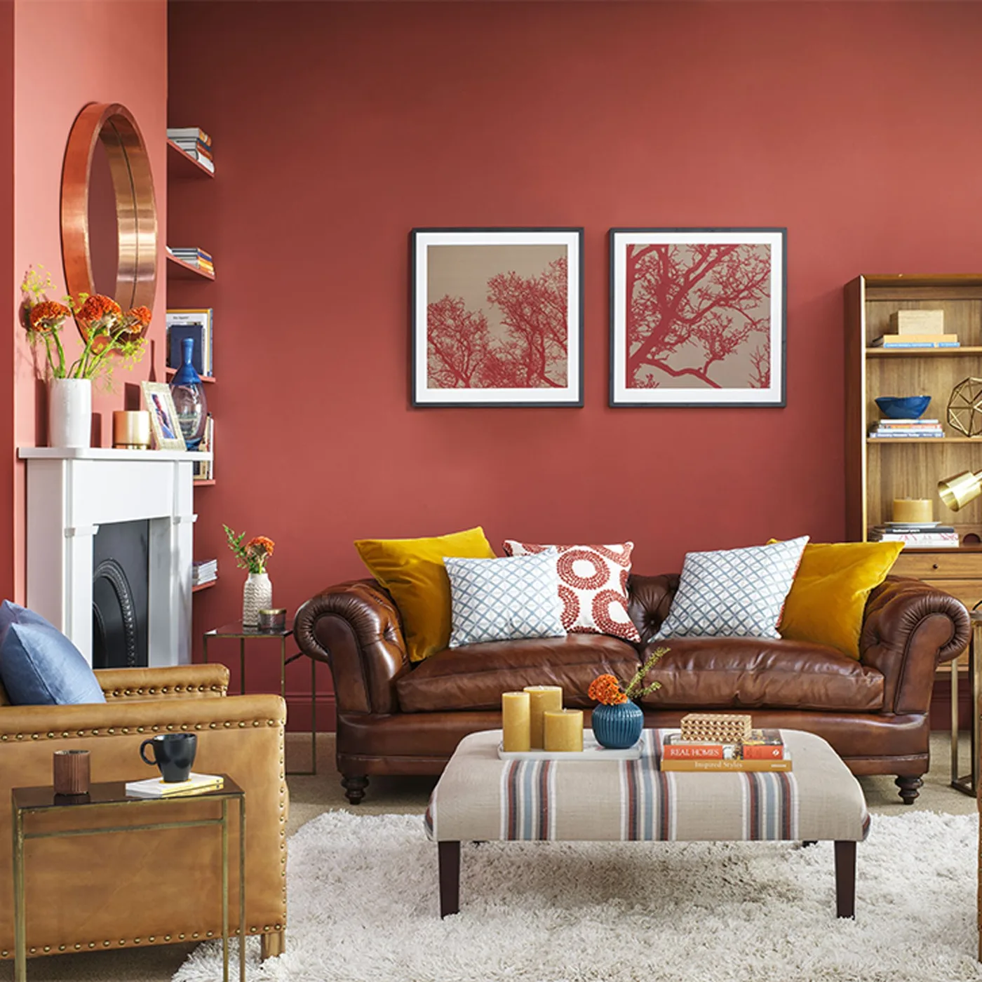 Brown rolled-arm couch with yellow end pillows, pale blue patterned pillows and a red circular-patterned center pillow.