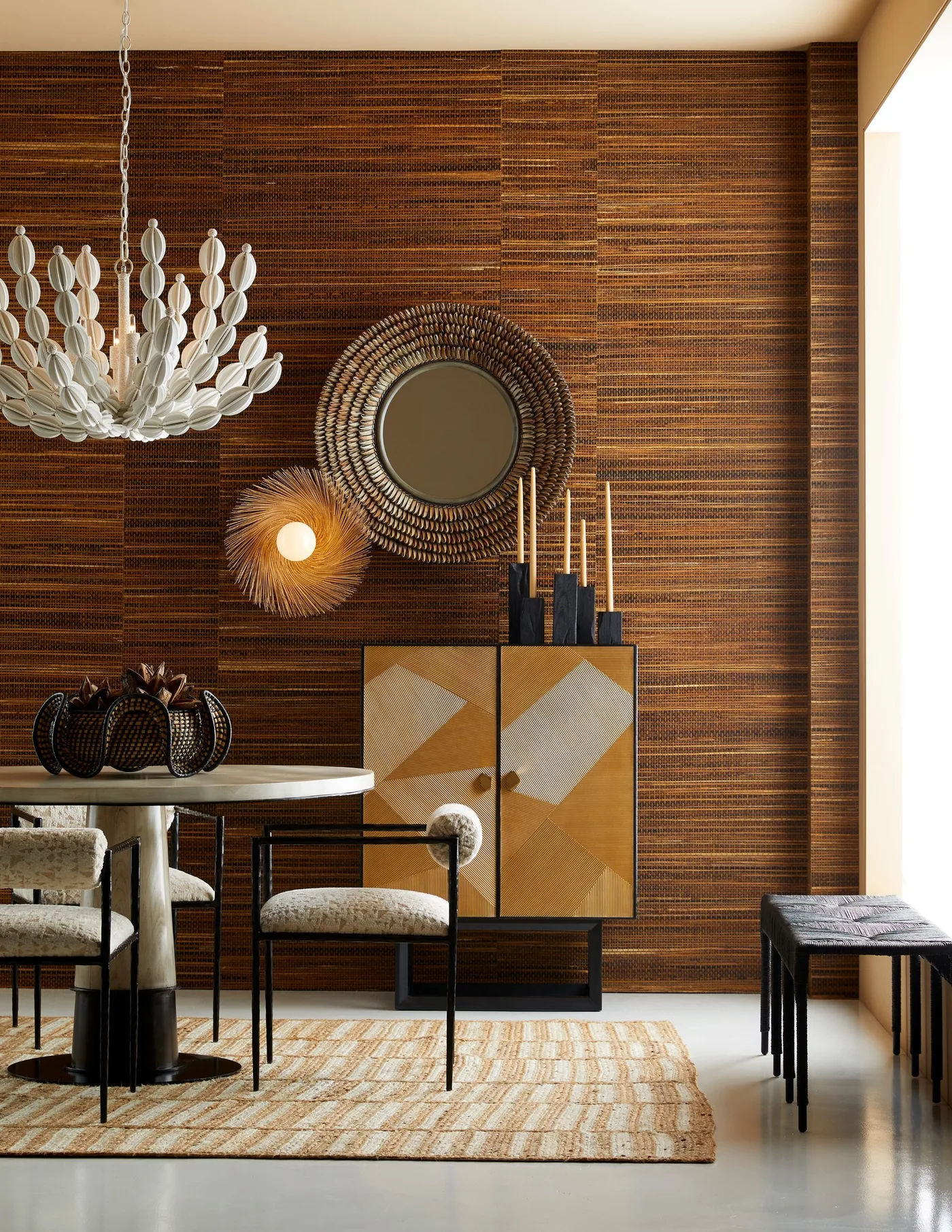 Narrow dining storage cabinet with geometric wood doors in a black frame beside a round table