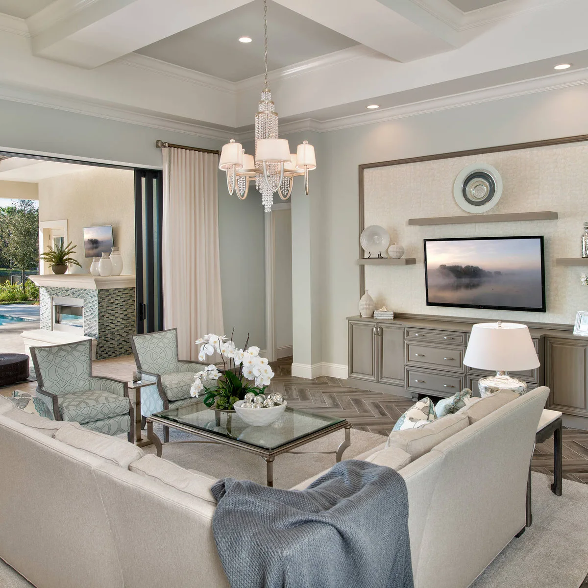 Pale TV wall with gray cupboards, floating shelves and a light textured backdrop