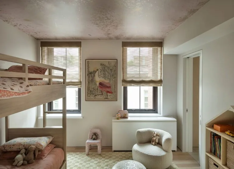 Children’s bedroom with pale bunk beds, two windows and a softly mottled celestial-patterned ceiling.