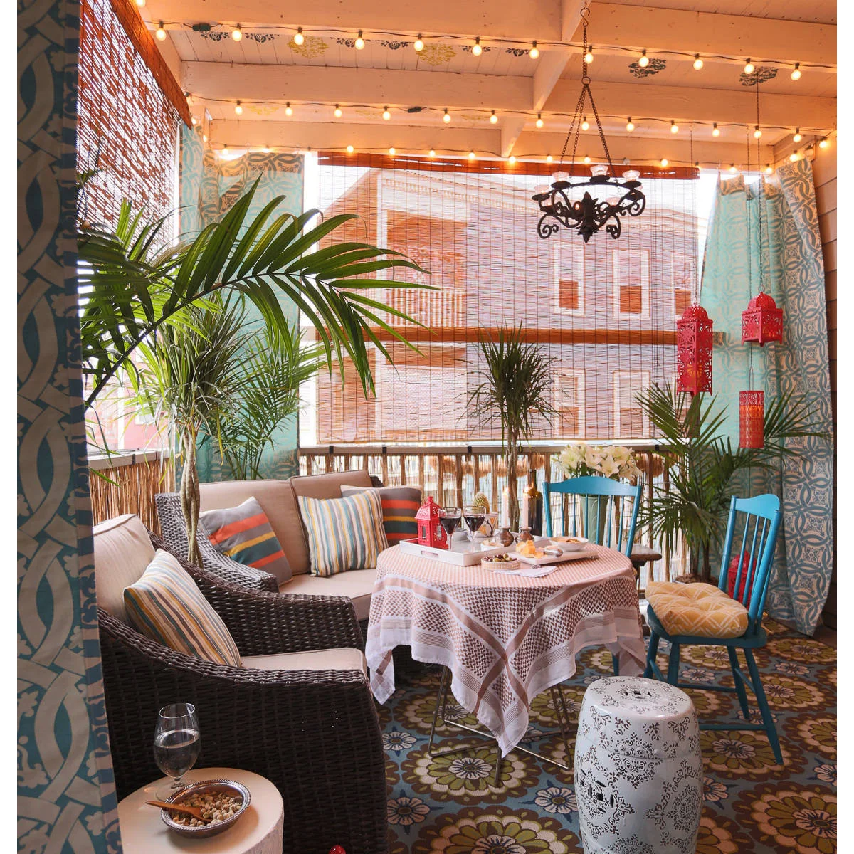 Woven roll-down shades and blue patterned curtains surround a covered seating and dining area