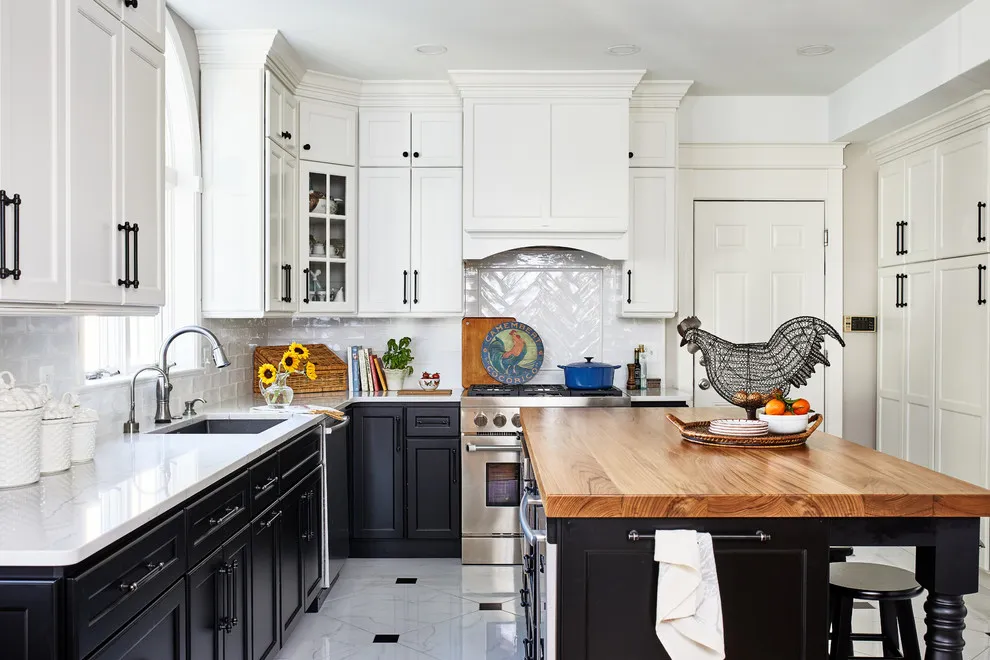 Dark lower cabinets sit beneath white upper fronts beside a timber-topped island