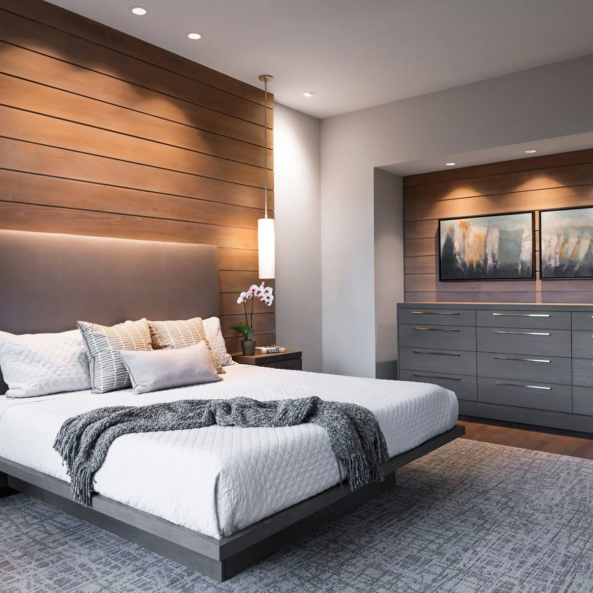 Brown horizontal wall panels behind a neutral bed and above a gray dresser in a recessed area.