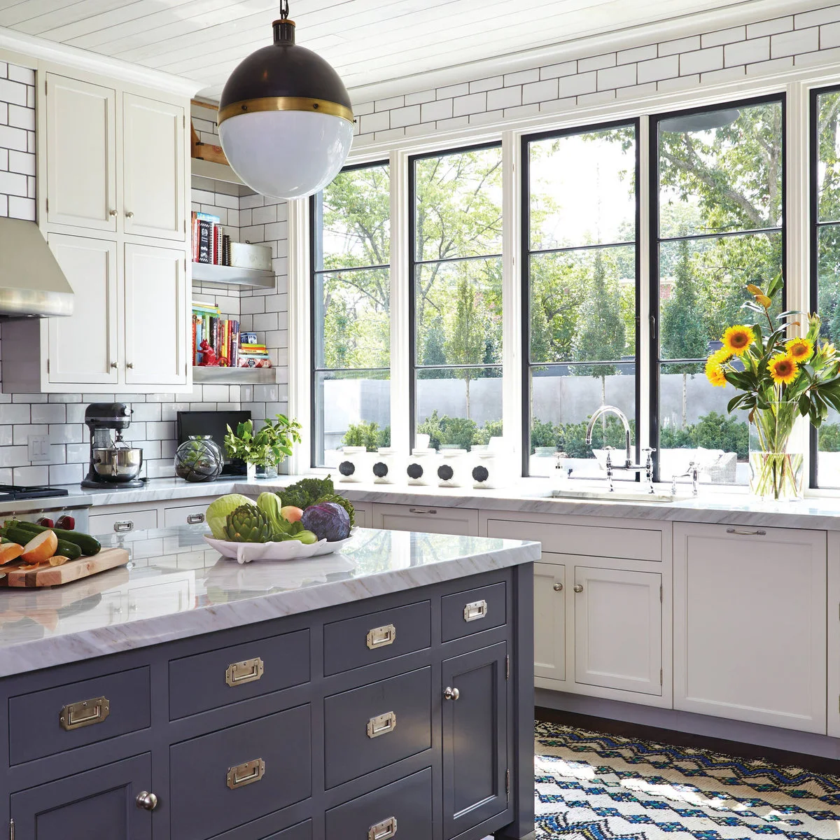 Dark kitchen island with small upper drawers and wider lower drawers beneath a pale top