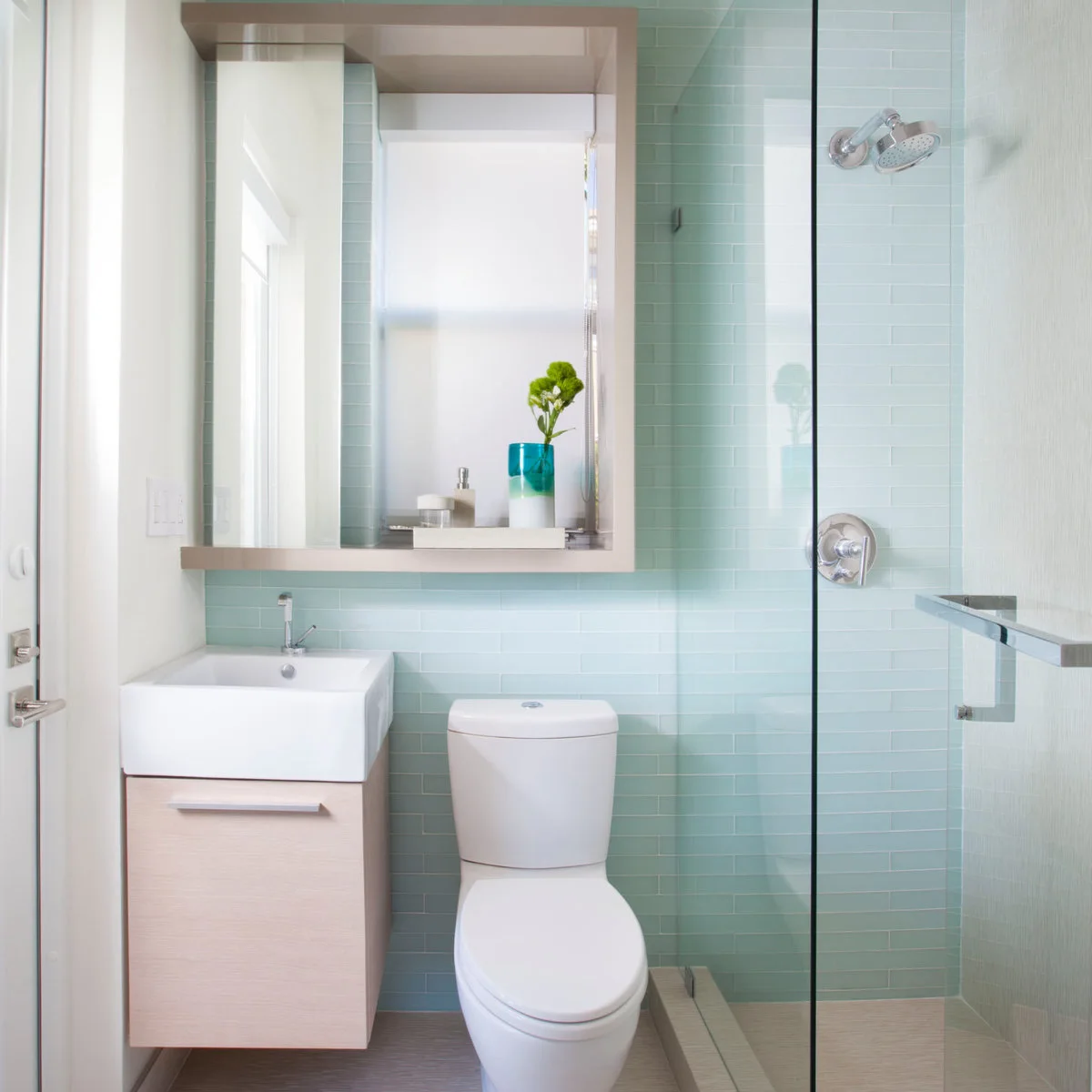 Small pale vanity with a narrow ledge beneath a large framed mirror