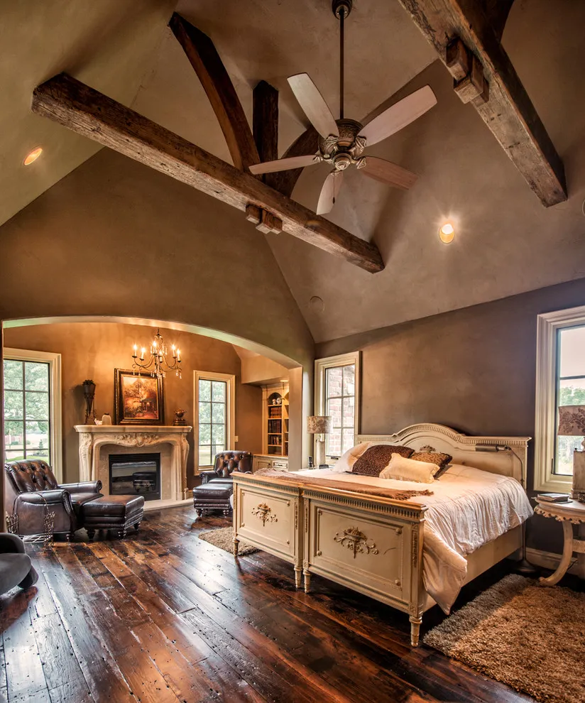 Dark floorboards run beneath a carved timber bed and exposed roof structure