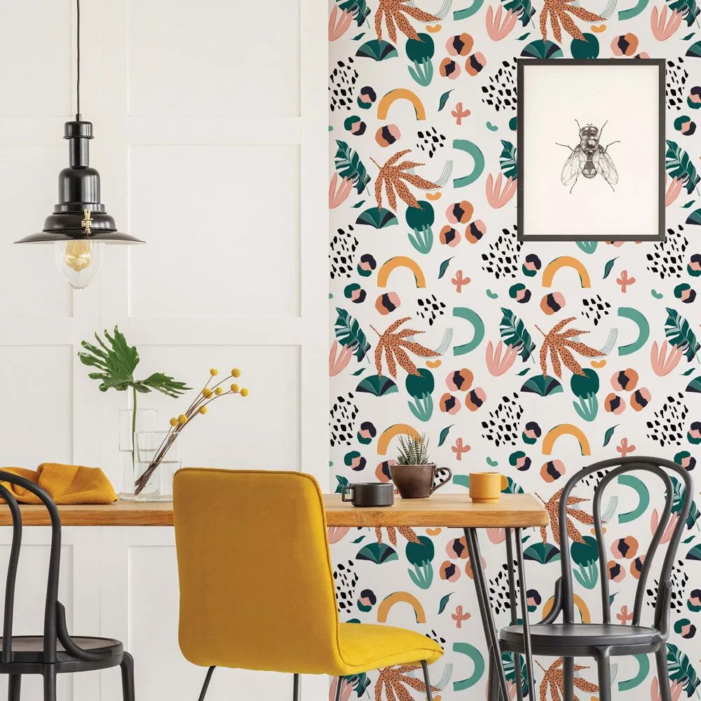 Framed monochrome insect drawing with a generous pale mat against pink-and-green botanical wallpaper, beside a wooden table, mustard chair, black chair, and dark pendant.