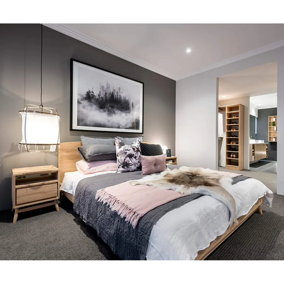 Bedroom with charcoal feature wall, wood-colored bed and pale pink textiles