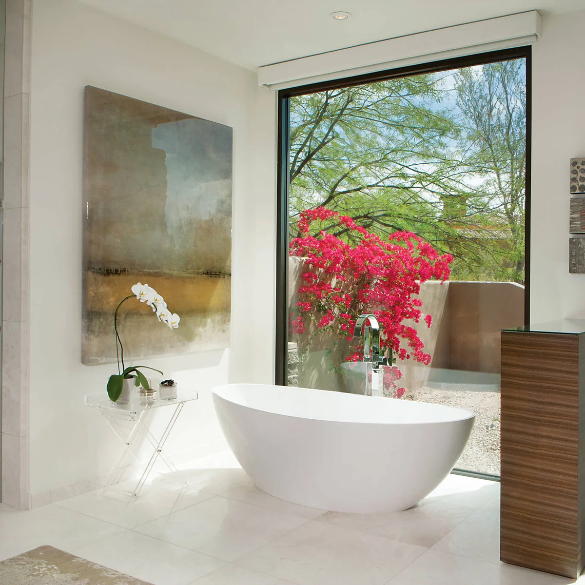 Large pale abstract artwork beside a freestanding tub and broad garden window