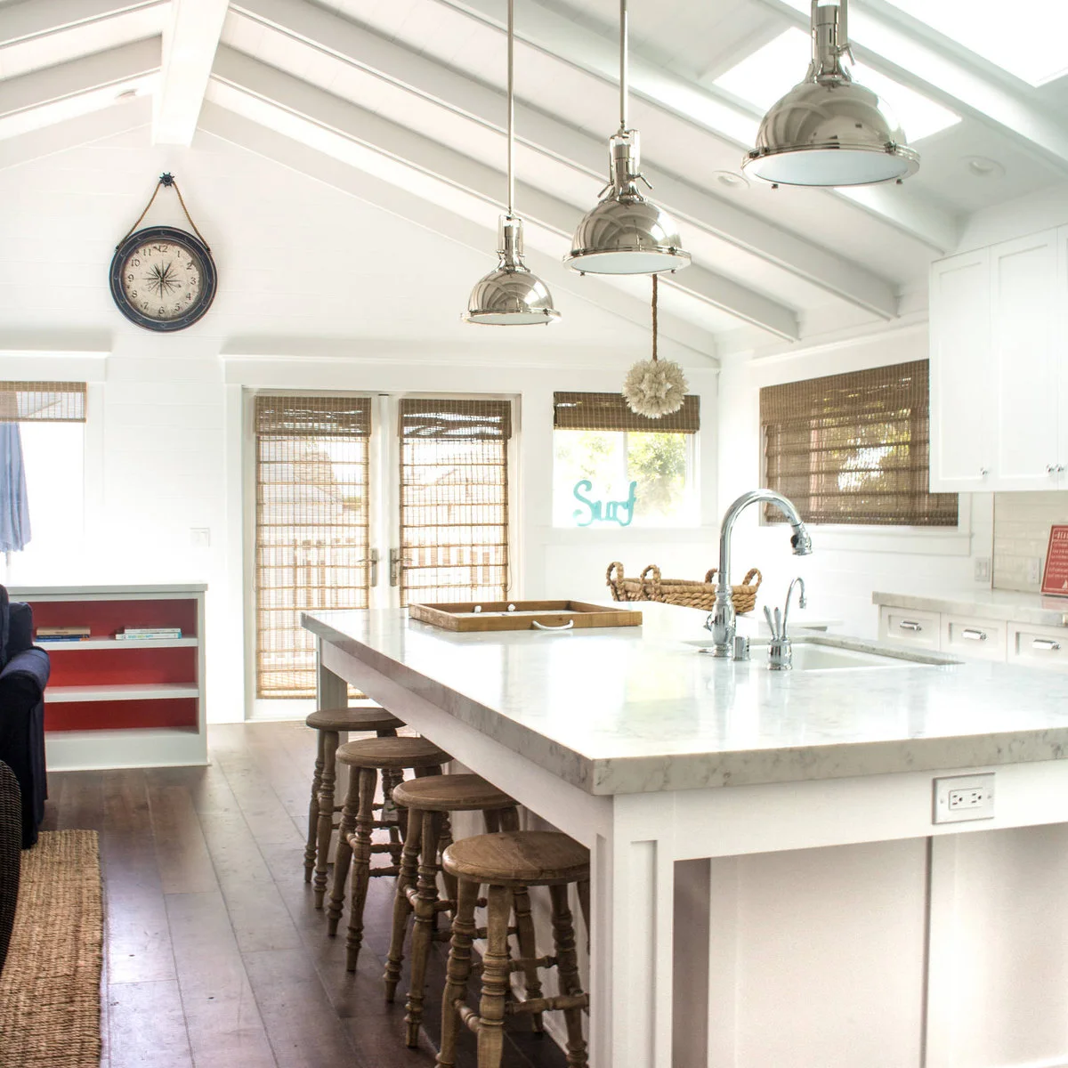 White boarded vaulted kitchen ceiling with white beams and metal pendant lights