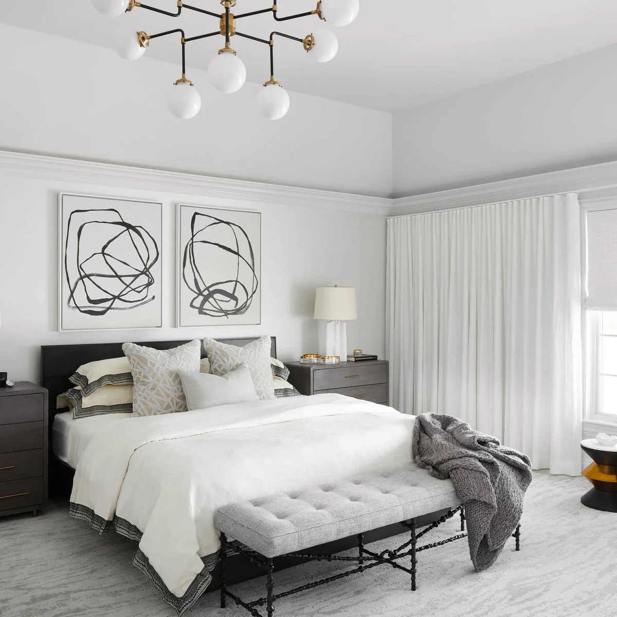 Dark bedside chests with several drawers beside a bed in a white bedroom