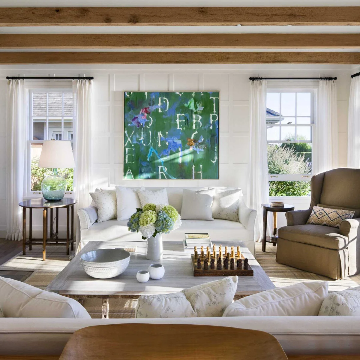 White paneled living-room wall with a large green artwork between two windows