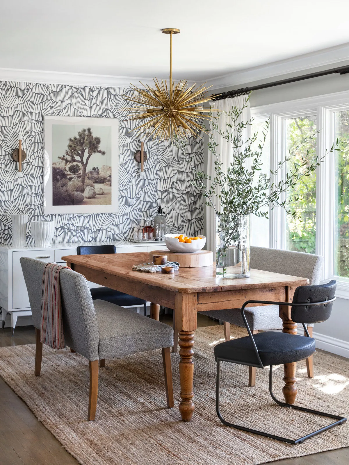 Fine gray pattern covers the walls behind a wood dining table and dark chairs.