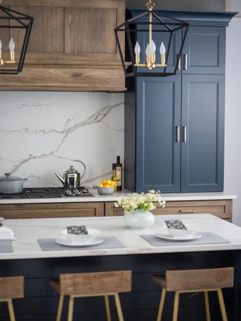 Blue tall cupboards stand beside timber cabinetry and pale stone-patterned surfaces.
