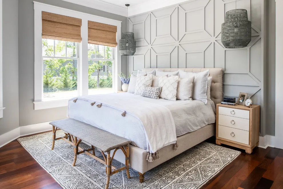Raised geometric trim covers the wall behind a pale upholstered bed