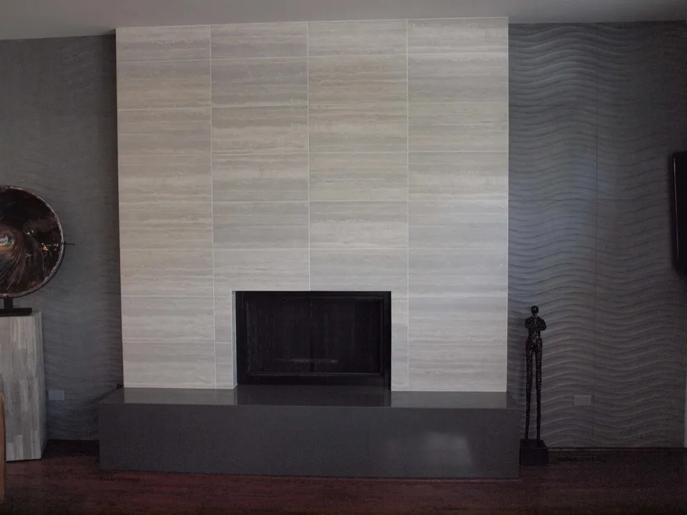 A pale tiled fireplace wall stands beside a dark gray painted section