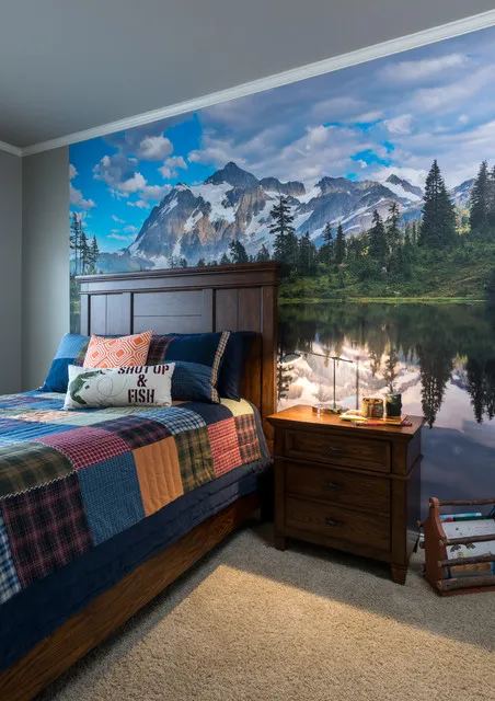 A mountain-and-water scene rises behind a dark timber bed with colorful bedding.