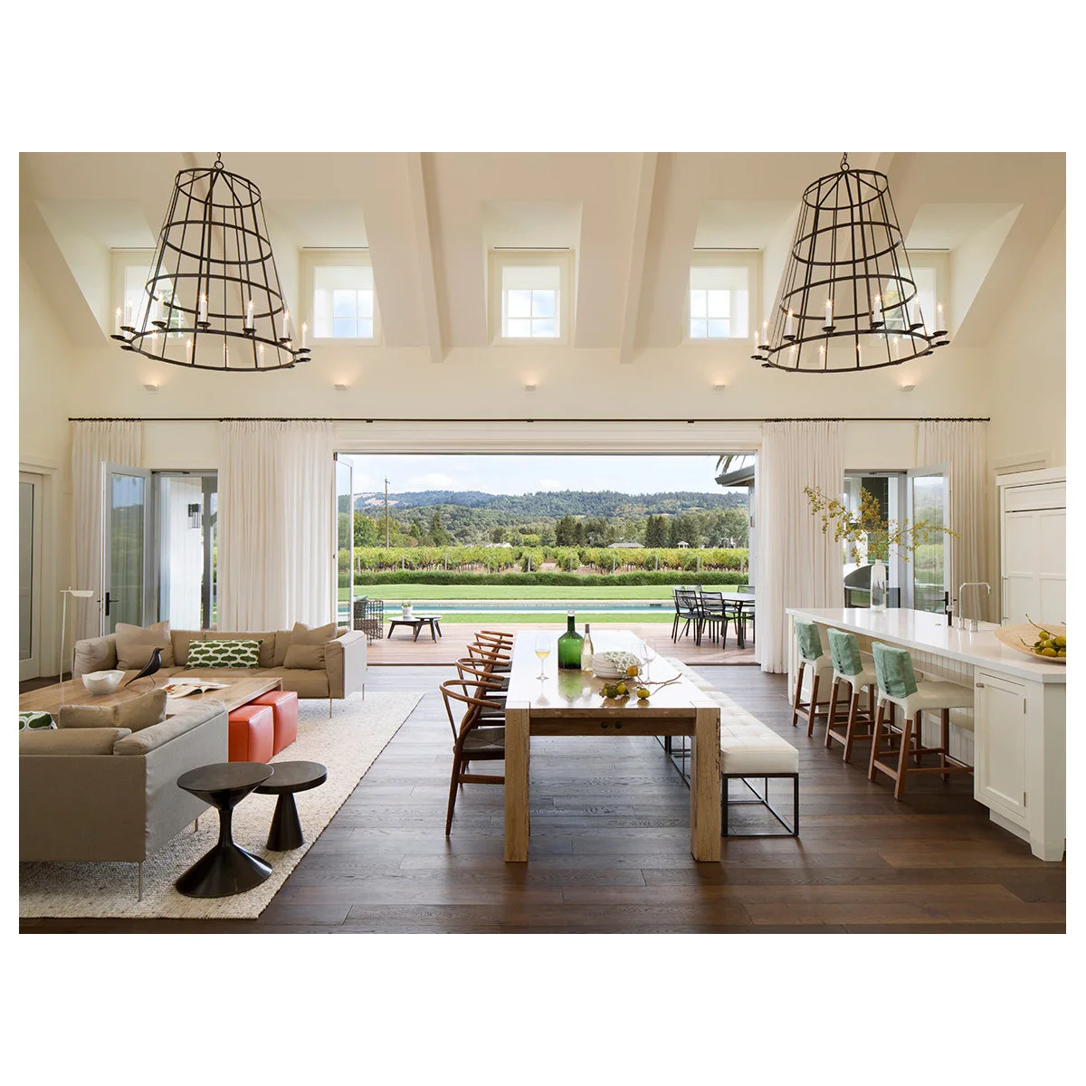 White curtains across a wide glazed opening in an open kitchen and dining room