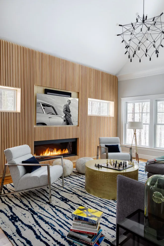 Vertical timber slats cover a fireplace wall beside a pale seating group