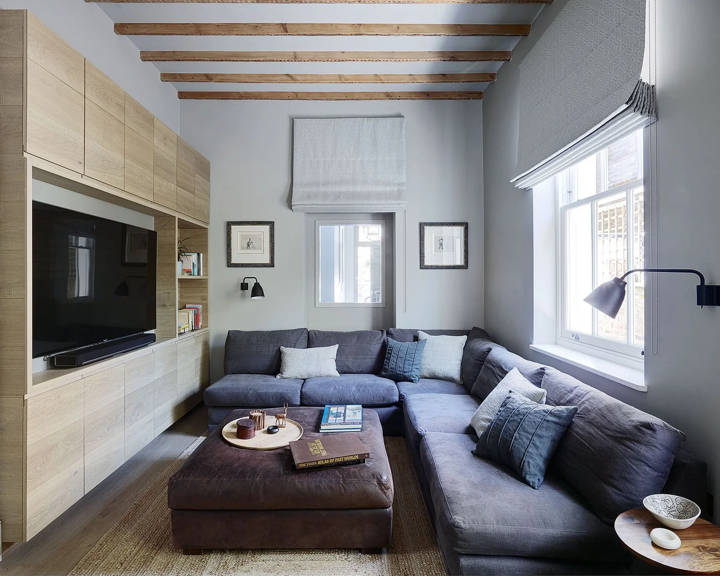 Compact gray living room with a TV within full-height wood-toned cabinets