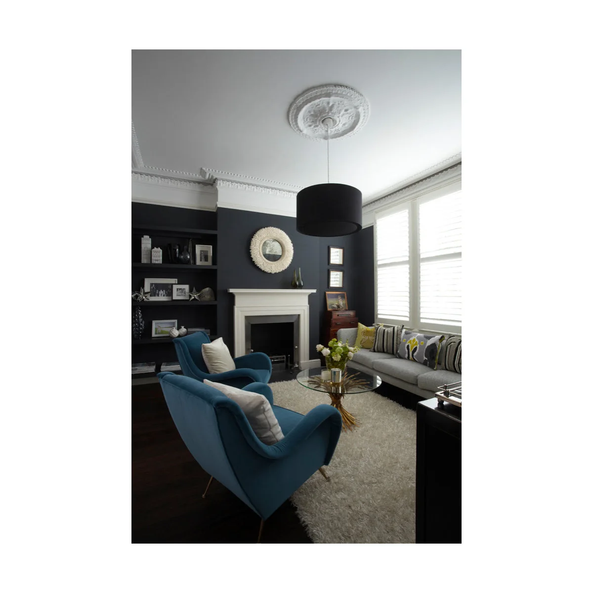 Dark-walled front room with blue chairs, gray sofa and pale ceiling decoration