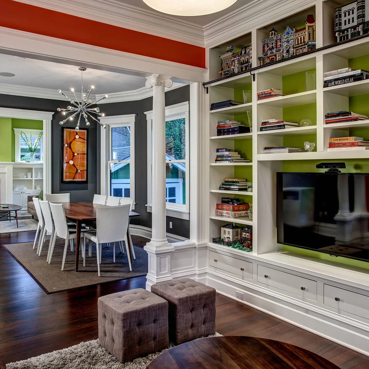 White media shelves with lime-green backs beside an open dining room