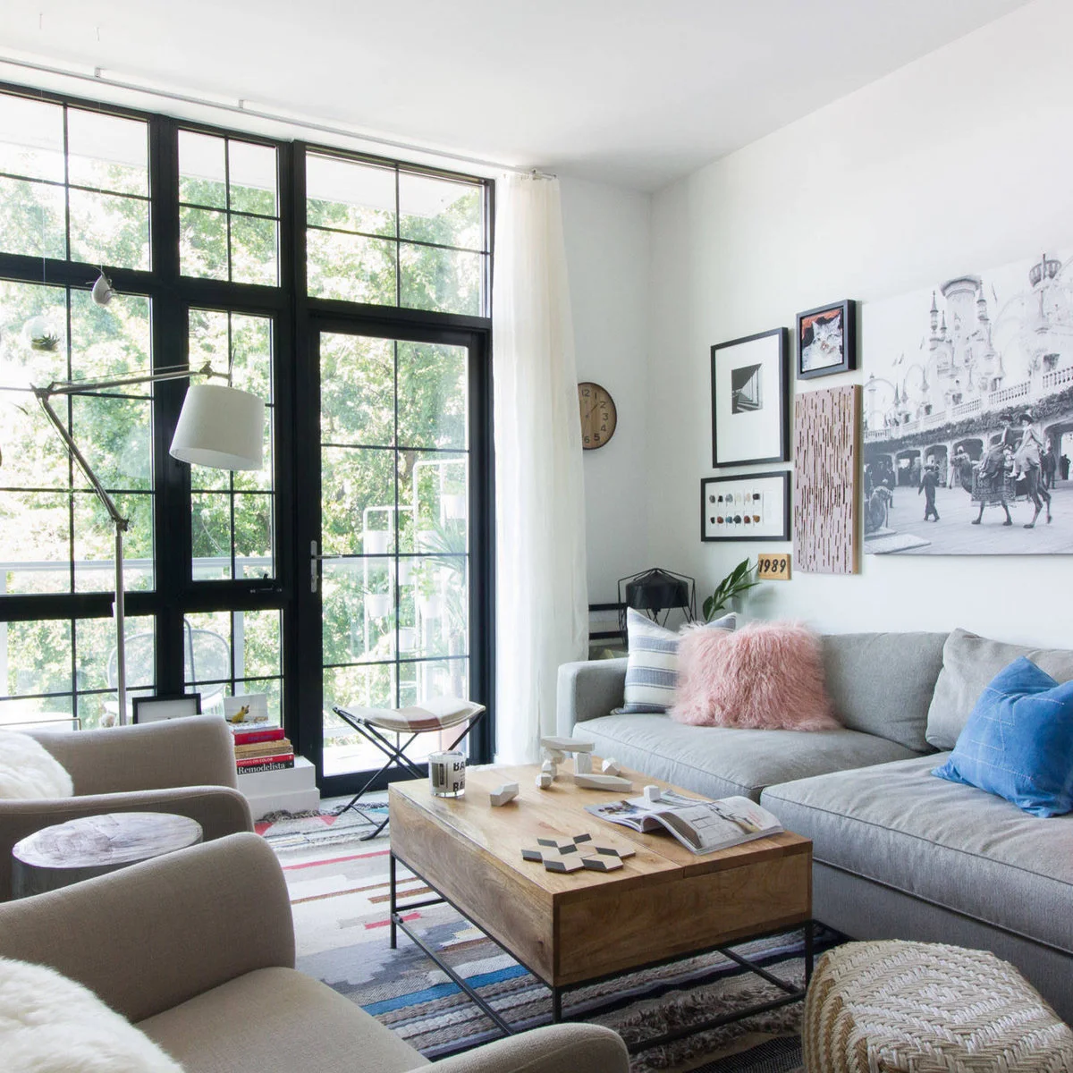 White-walled living room with a grey sofa, two armchairs and a wood coffee table