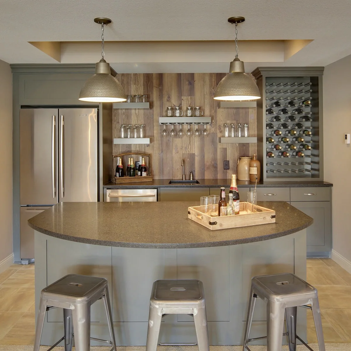 Basement bar with curved gray counter front, metal stools and open glass storage