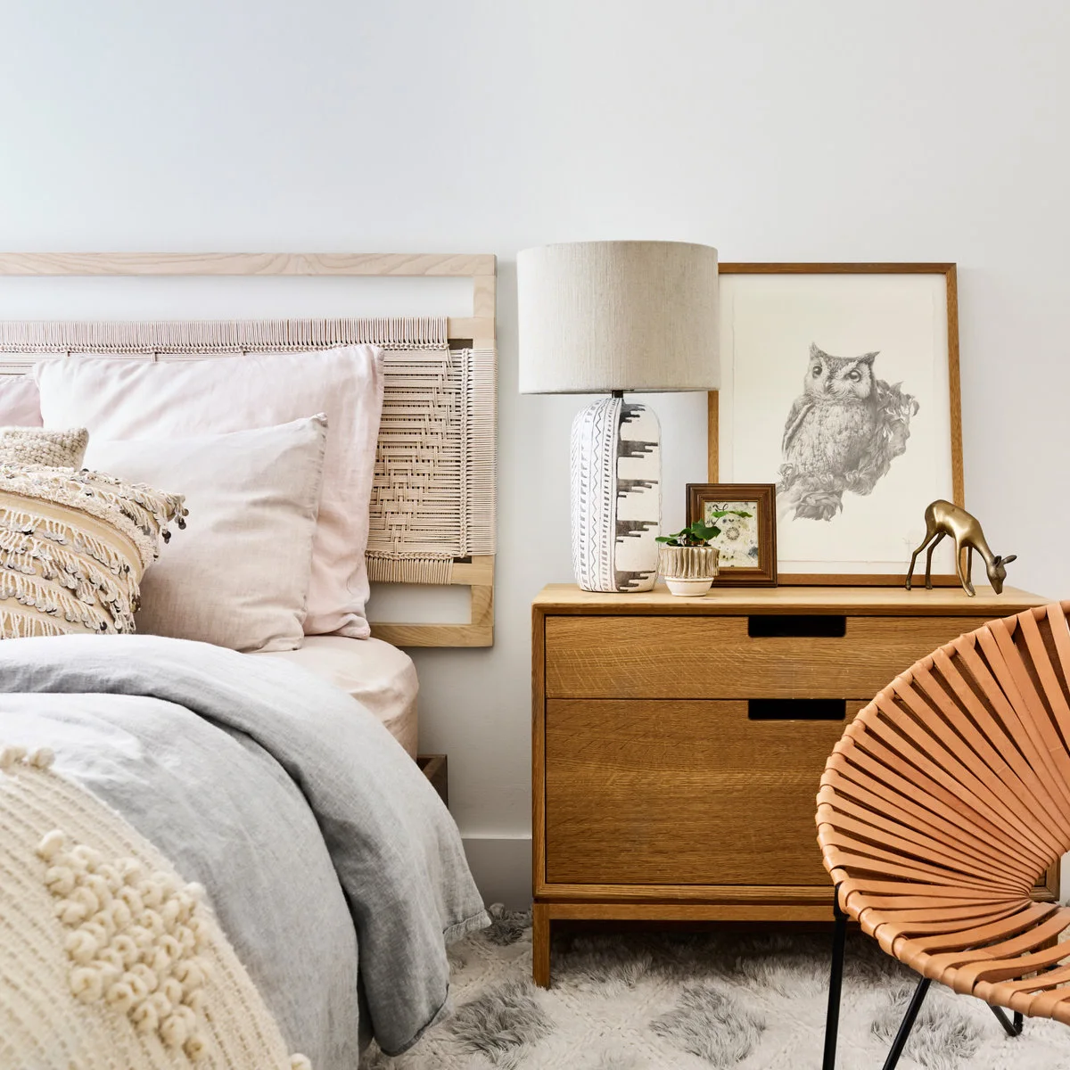 Wooden two-drawer bedside chest with lamp, owl print and small framed picture