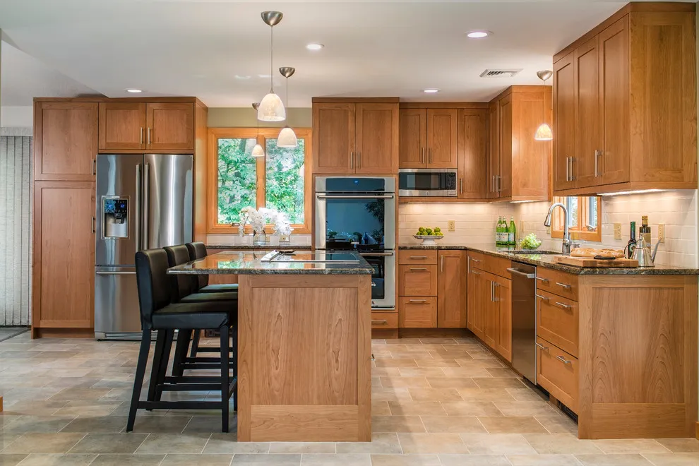 Plain wood cabinet fronts surround a compact island and a bright sink window