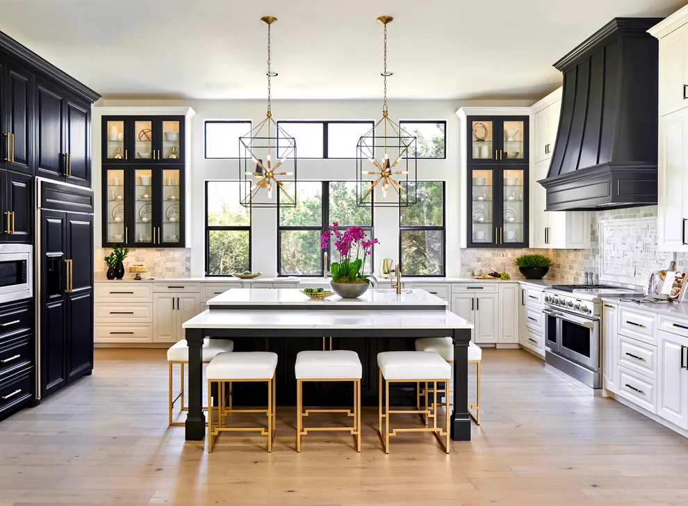Dark tall cabinets and a dark island contrast with white lower drawers around a bright kitchen window