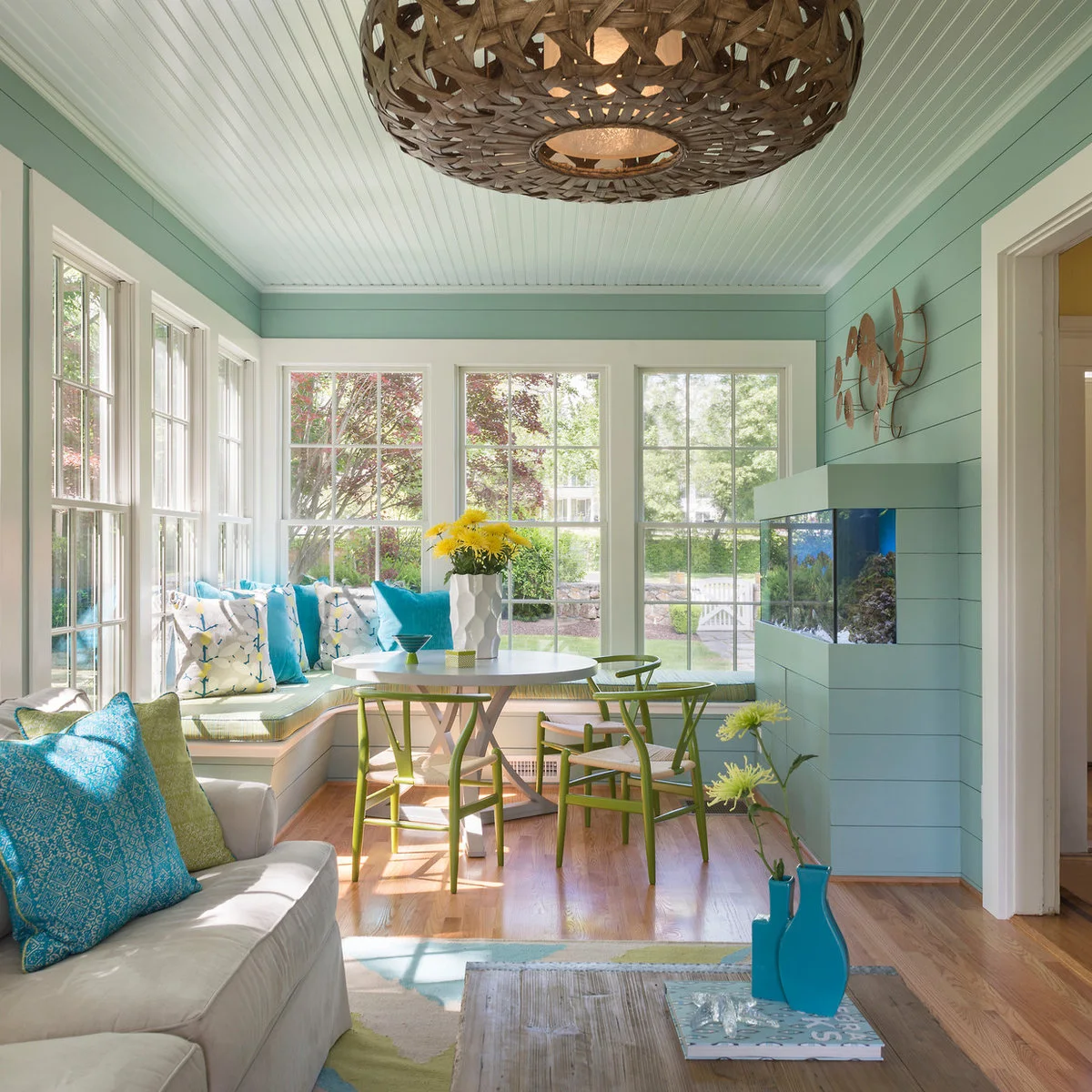 White finely grooved ceiling over a turquoise sitting room and round dining table