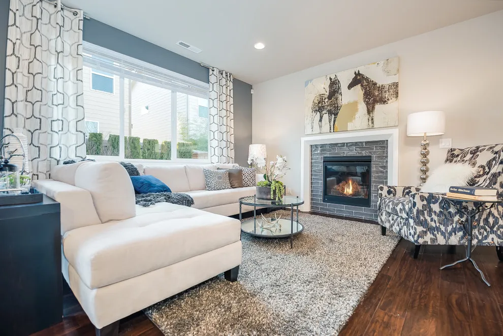 A blue section above a window is framed by patterned curtains beside a white sectional