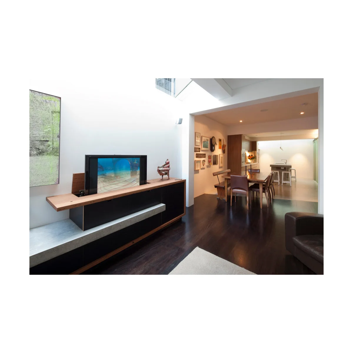 Newtown terrace interior with a low media unit, pale living area and dining space beyond