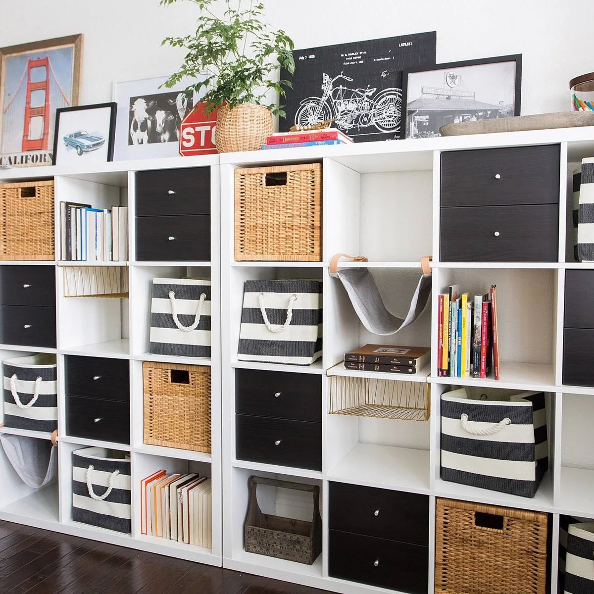White cubby storage wall with black drawers, striped bins, woven-looking baskets and books