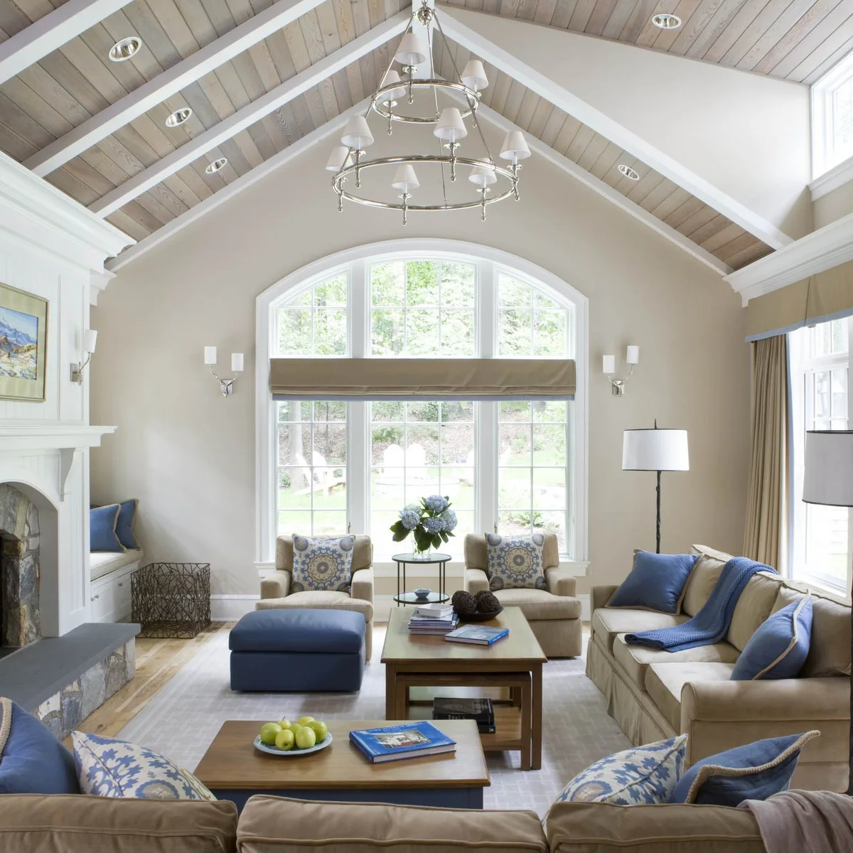 Lightwashed ceiling boards between white rafters over a blue and cream living room