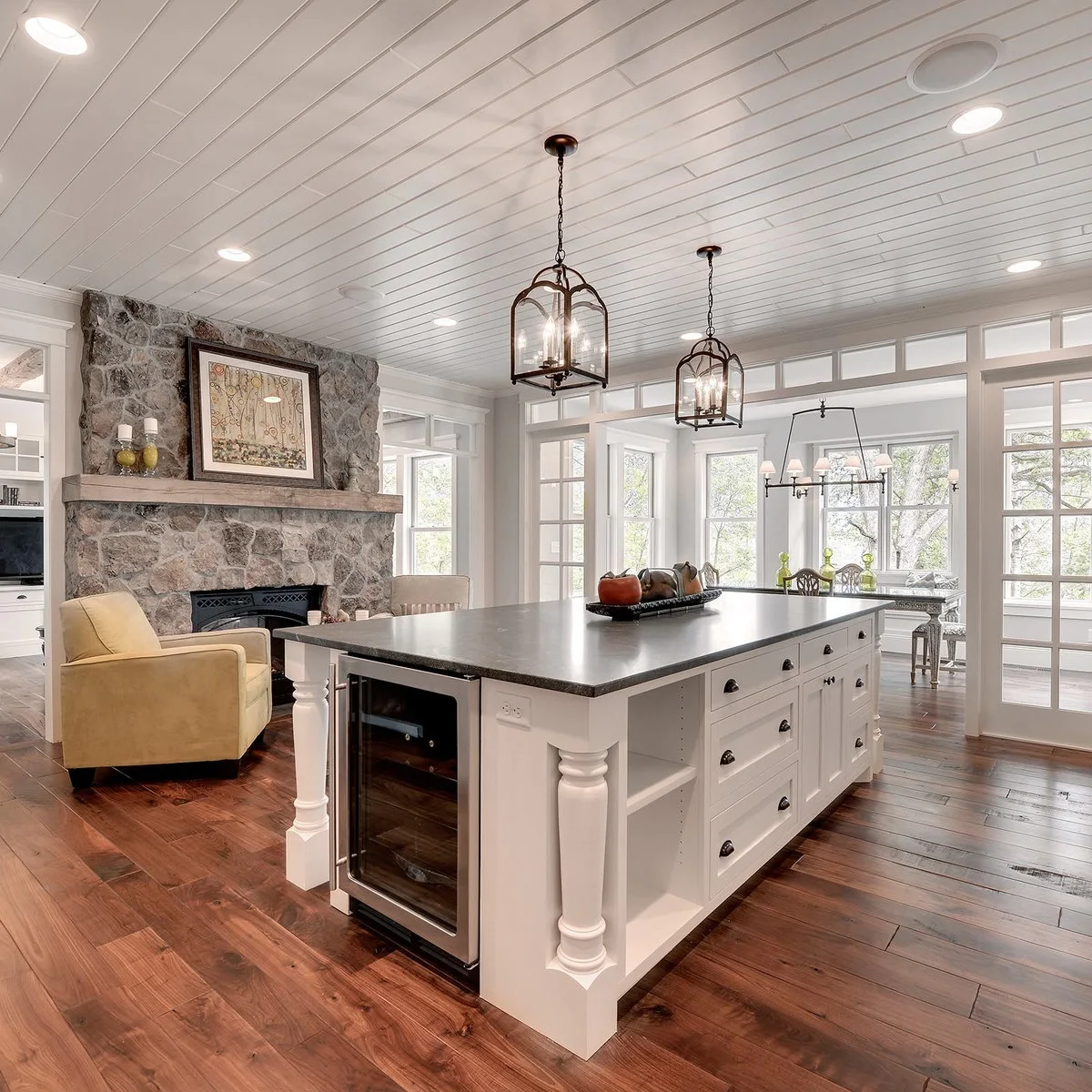 White kitchen island with an end beverage cooler and narrow open shelves beside drawers